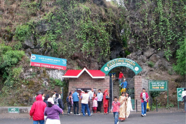 Tourists exploring the cave passages lit with colorful lights.