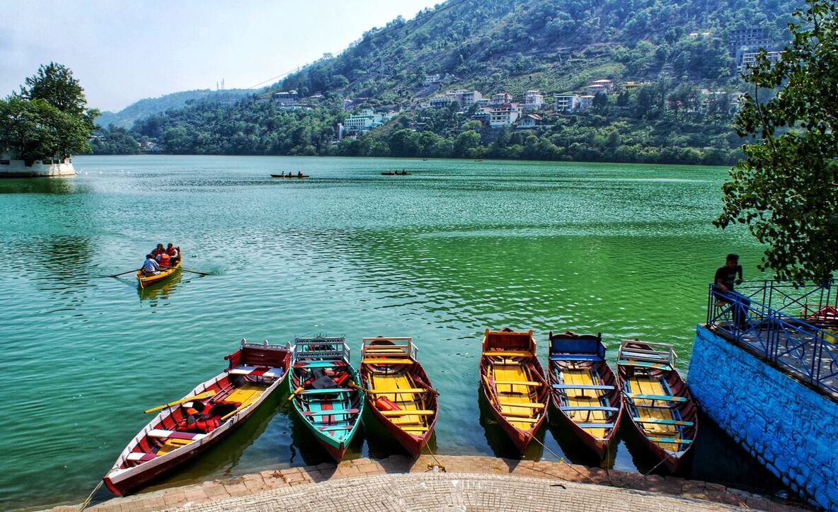 Scenic view of Nainital Lake with surrounding hills.