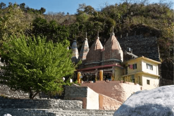 Jhula Devi Temple Ranikhet surrounded by pine trees.