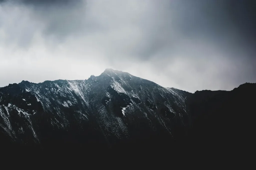 Grey mountain landscape in Nainital with light snowfall and cloudy winter skies