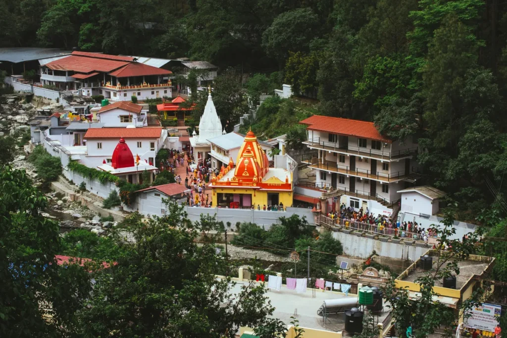 Aerial view of Kainchi Dham Neem Karoli Baba Ashram in Uttarakhand surrounded by green hills.