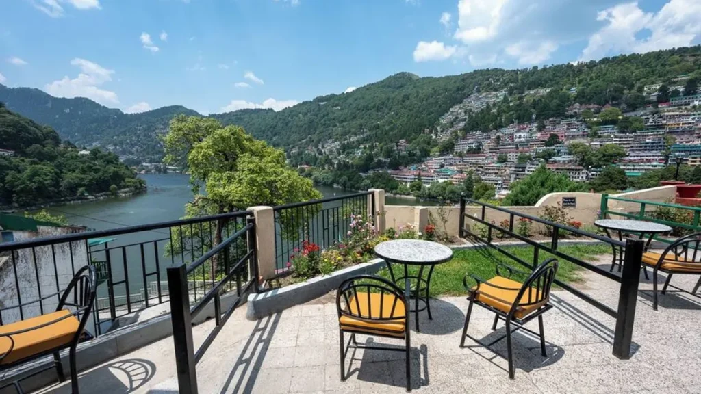 Outdoor seating area of Hotel Himalaya overlooking Naini Lake and the lush green hills of Nainital, offering scenic lake-view accommodation for a relaxing summer stay.