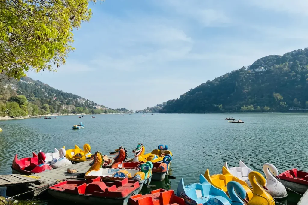 Colorful paddle boats at Nainital Lake during a peaceful afternoon visit