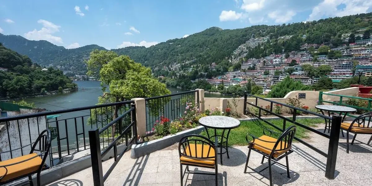 Lake view seating area at Hotel Himalaya Nainital overlooking Naini Lake and surrounding hills under a clear blue sky.