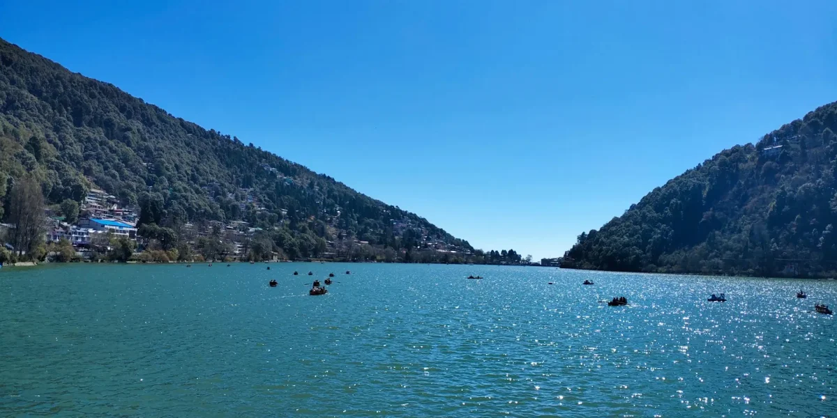 Nainital tour scenic lake view with boats and surrounding hills in Uttarakhand